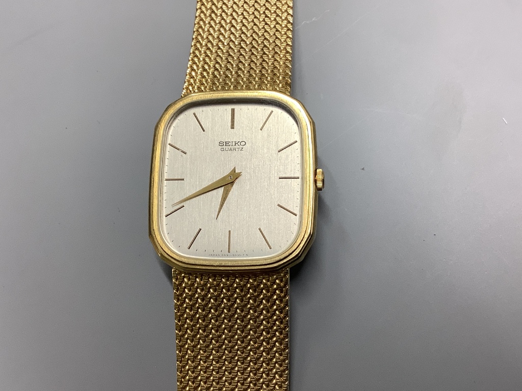 A gentleman's modern 9ct gold Seiko quartz wrist watch on integral 9ct gold mesh link bracelet. overall 20.5cm